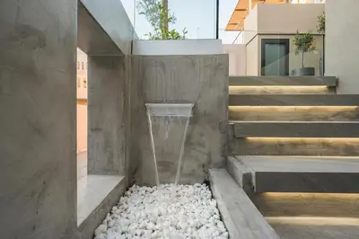 a water fountain on the side of a building with rocks at Casa D'Irene Deluxe Hotel in Falasarna