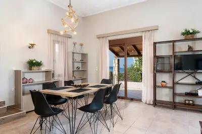a dining room with a table and black chairs at Lila hill house in Stalos