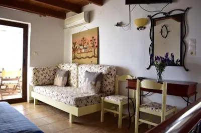 a room with a couch and a table and a mirror at Marinakis Sea View Studios in Sougia