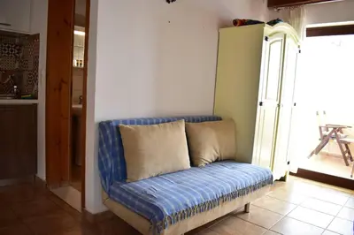 a blue couch in a room with a window at Marinakis Sea View Studios in Sougia