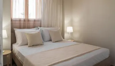 a white bed with white pillows and a window at Aelia Apartments in Chania Town