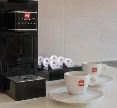 two cups on plates next to a coffee maker at Aelia Apartments in Chania Town