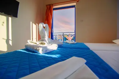 a bedroom with a bed with a swan on it at Scorpios Family Rooms in Palaiochóra