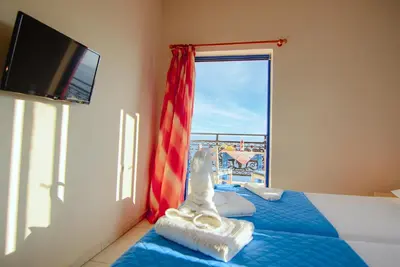 a bedroom with a bed and a window with a view at Scorpios Family Rooms in Palaiochóra