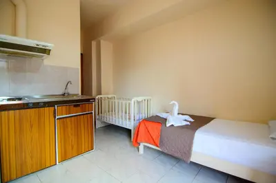 a bedroom with a bed and a sink and a crib at Scorpios Family Rooms in Palaiochóra