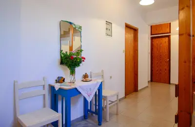 a room with a blue table with chairs and a mirror at Scorpios Family Rooms in Palaiochóra