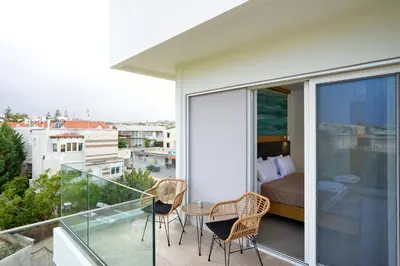 a bedroom with a balcony with a bed and a table at Elia Kalamaki Hotel in Kalamaki Chanion