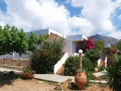 a white house with flowers in front of it at Fragokastello Star in Frangokastello