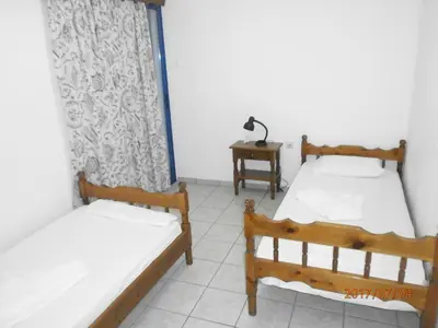 a room with two beds and a table with a lamp at Fragokastello Star in Frangokastello