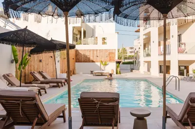 a pool with chairs and umbrellas next to a building at Evexia Boutique Hotel & Spa in Agia Marina Nea Kydonias