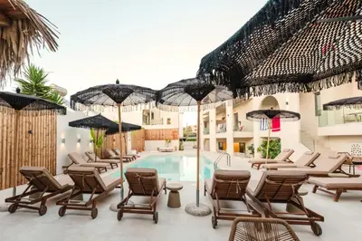 a patio with chairs and umbrellas next to a pool at Evexia Boutique Hotel & Spa in Agia Marina Nea Kydonias