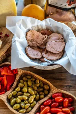 a table with a basket of meat and a plate of olives at Evexia Boutique Hotel & Spa in Agia Marina Nea Kydonias