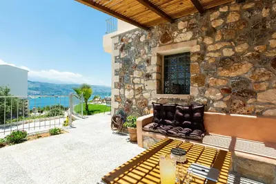 a stone building with a bench on a patio at Istros Villas - with Pools, BBQ & Heated Spa Whirlpools, By ThinkVilla in Korakiaí