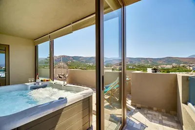 a bathroom with a tub with a view of the mountains at Lydia's Apartments in Kissamos