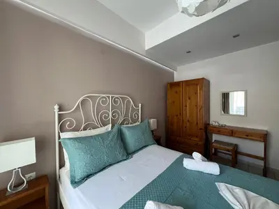 a bedroom with a bed with green pillows at Artemis Rooms two steps by the sea in Plataniás