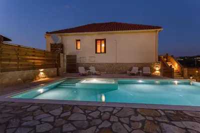 a villa with a swimming pool at night at Olive Villas in Kría Vrísi