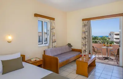 a hotel room with a couch and a balcony at Dias Hotel Apartments in Agia Marina Nea Kydonias