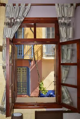 a window with a potted plant in a room at Enetiko Rooms in Chania Town