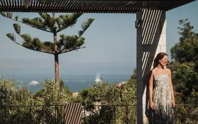 a woman in a silver dress standing on a balcony at Royal Sun in Chania Town