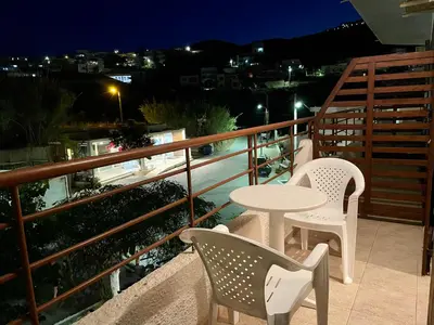 a table and chairs on a balcony at night at Lefka in Kolymvari