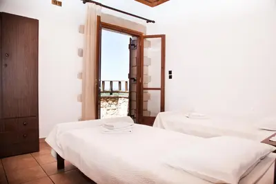 two beds in a room with a window at Tsivaras Villas in Tsivarás