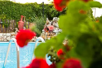 a child playing in a garden by a swimming pool at Tsivaras Villas in Tsivarás