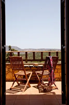 two chairs sitting on a porch with a table at Tsivaras Villas in Tsivarás