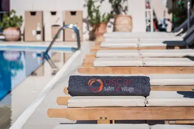 a row of seats next to a swimming pool at Oscar Suites & Village in Agia Marina Nea Kydonias