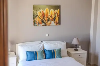 a bedroom with a bed with a painting above it at Orion Star in Agia Marina Nea Kydonias