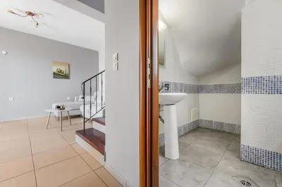 a bathroom with a sink and a staircase at Orion Star in Agia Marina Nea Kydonias