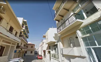 an alleyway between two buildings with a red car on it at Sea View Penthouse with Roof Garden in Chania Town