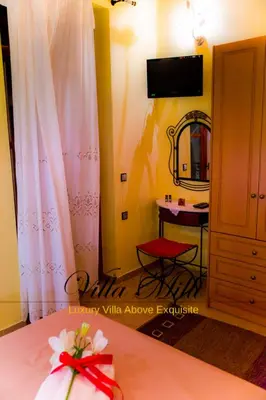 a room with a bed with a table and a mirror at Villa Milli in Chania Town