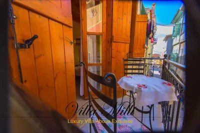 a table and chair on the balcony of a building at Villa Milli in Chania Town