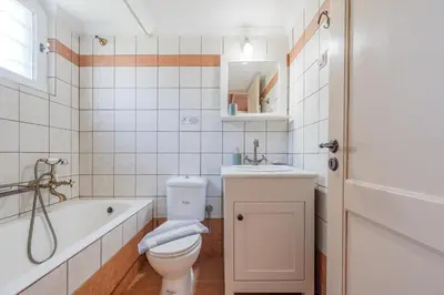 a bathroom with a toilet and a tub and a sink at Helianthos Villas in Douliana