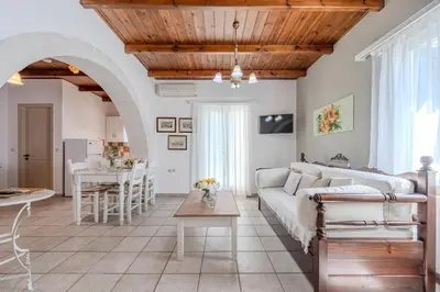 a living room with a couch and a table at Helianthos Villas in Douliana