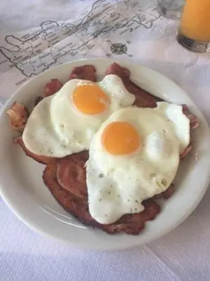 two fried eggs on top of toast on a plate at Oriental Bay in Palaiochóra