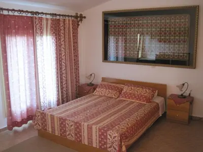 a bedroom with a bed and a mirror and curtains at Vamos Palace Apartments in Vamos