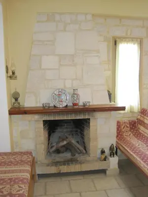 a living room with a stone fireplace with a plate on it at Vamos Palace Apartments in Vamos