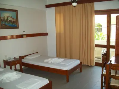 a hotel room with two beds and a window at Kato Stalos Beach in Stalos