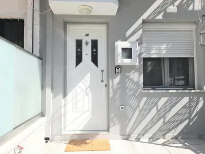 a white door on a white wall with a window at Apartment Split Level in Chania Town