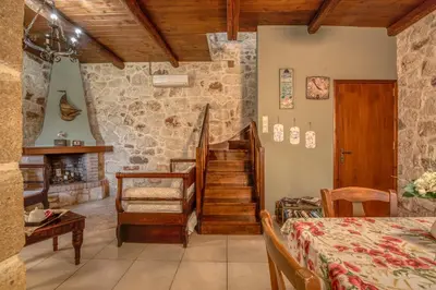 a living room with a staircase in a stone building at The Stonemade Houses in Falasarna