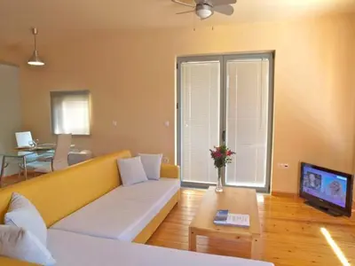 a living room with a couch and a tv at Sorta Apartments in Kato Daratso