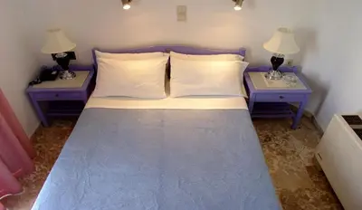 a bedroom with two nightstands and a bed with two lamps at Doreen Suites in Kalamaki Chanion