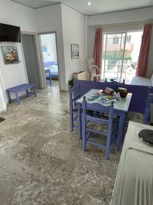 a living room with a blue table and chairs at Doreen Suites in Kalamaki Chanion
