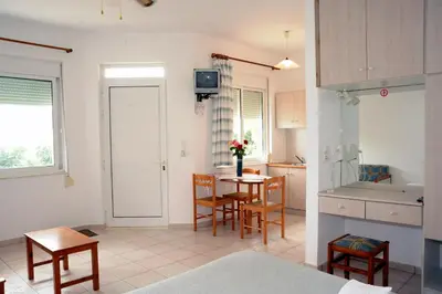 a kitchen with a table and chairs in a room at Evilion hotel in Stalos