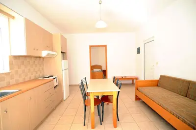 a kitchen and dining room with a table and a couch at Evilion hotel in Stalos