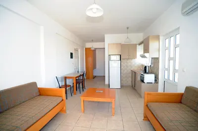 a living room with two couches and a table and a kitchen at Evilion hotel in Stalos
