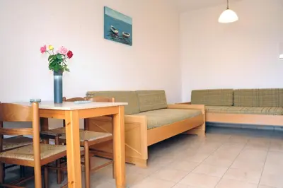 a waiting room with couches and a table with a vase of flowers at Evilion hotel in Stalos