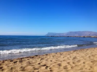 a beach with the ocean and mountains in the background at Eleni in Kissamos