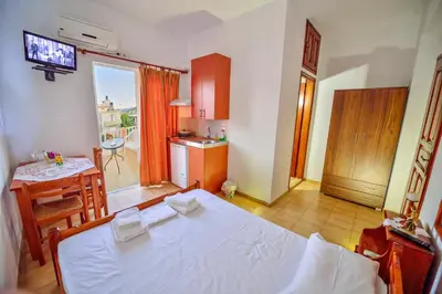 a bedroom with a bed and a table and a kitchen at Eleni in Kissamos